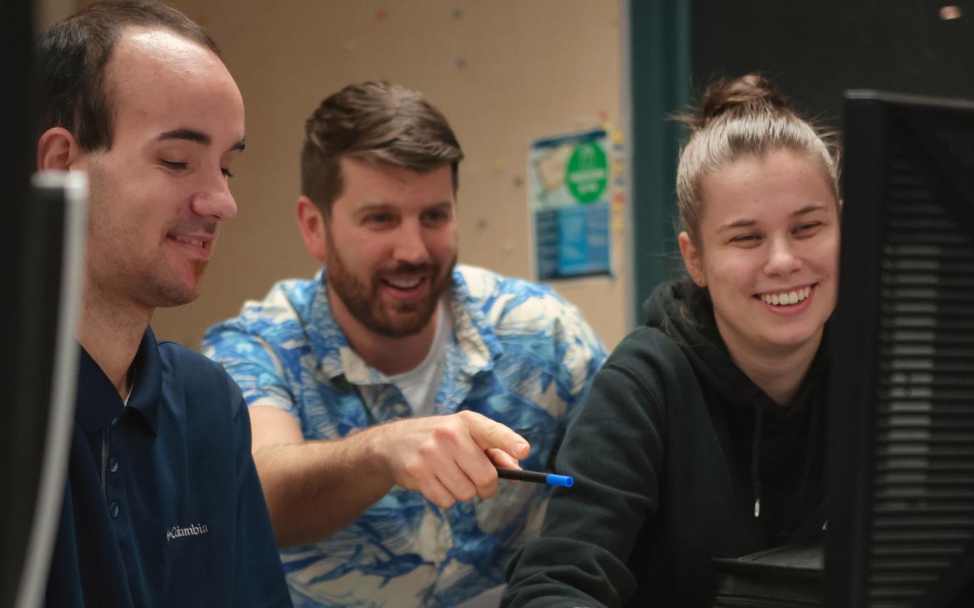 Three people looking at a computer screen together